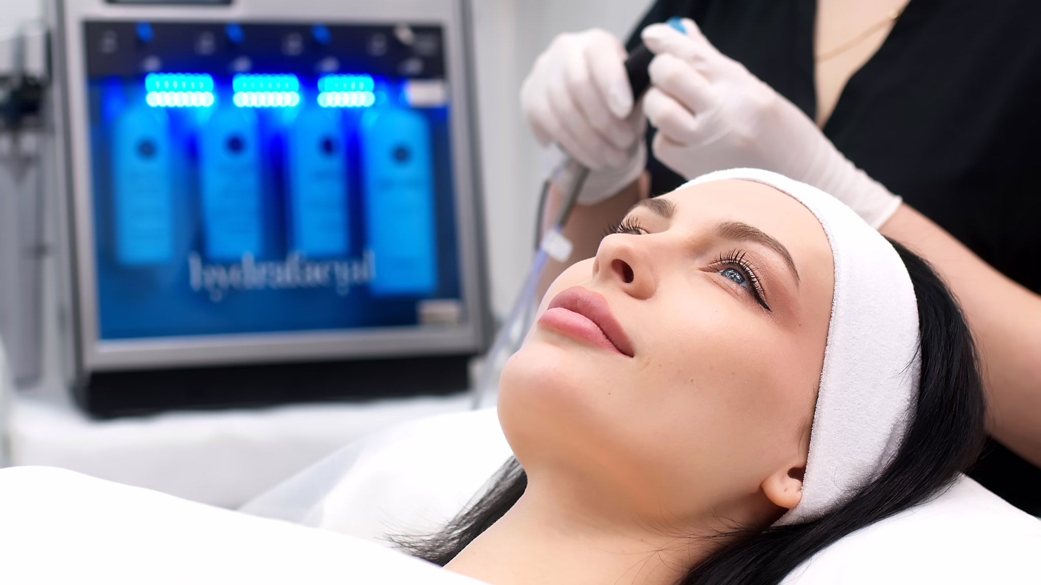 Woman receiving a HydraFacial® treatment in a spa setting — glowing skin and relaxed expression, highlighting hydration and radiance.